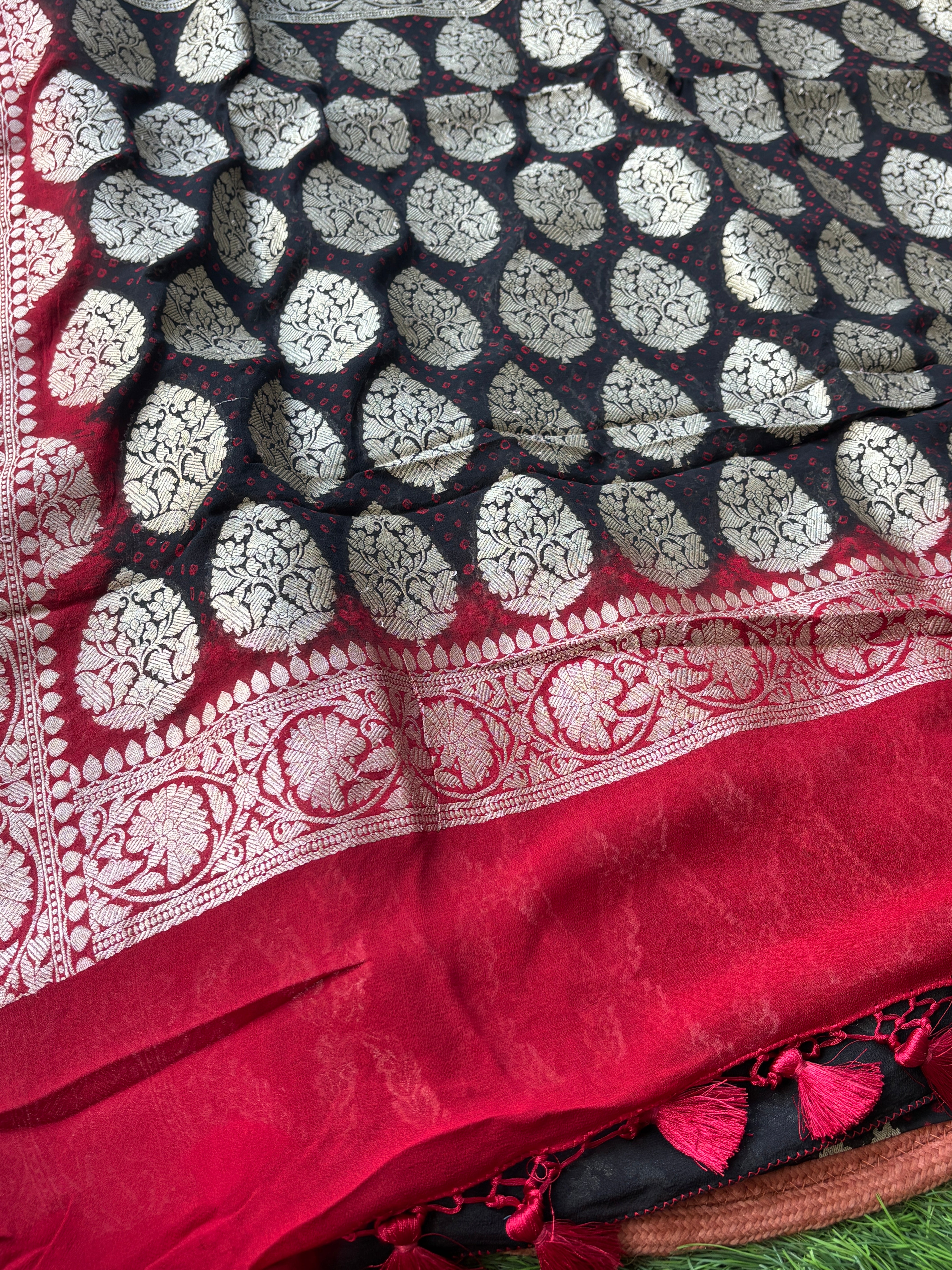 Close-up of golden zari woven motifs on black pure Khaddi Georgette Banarasi saree