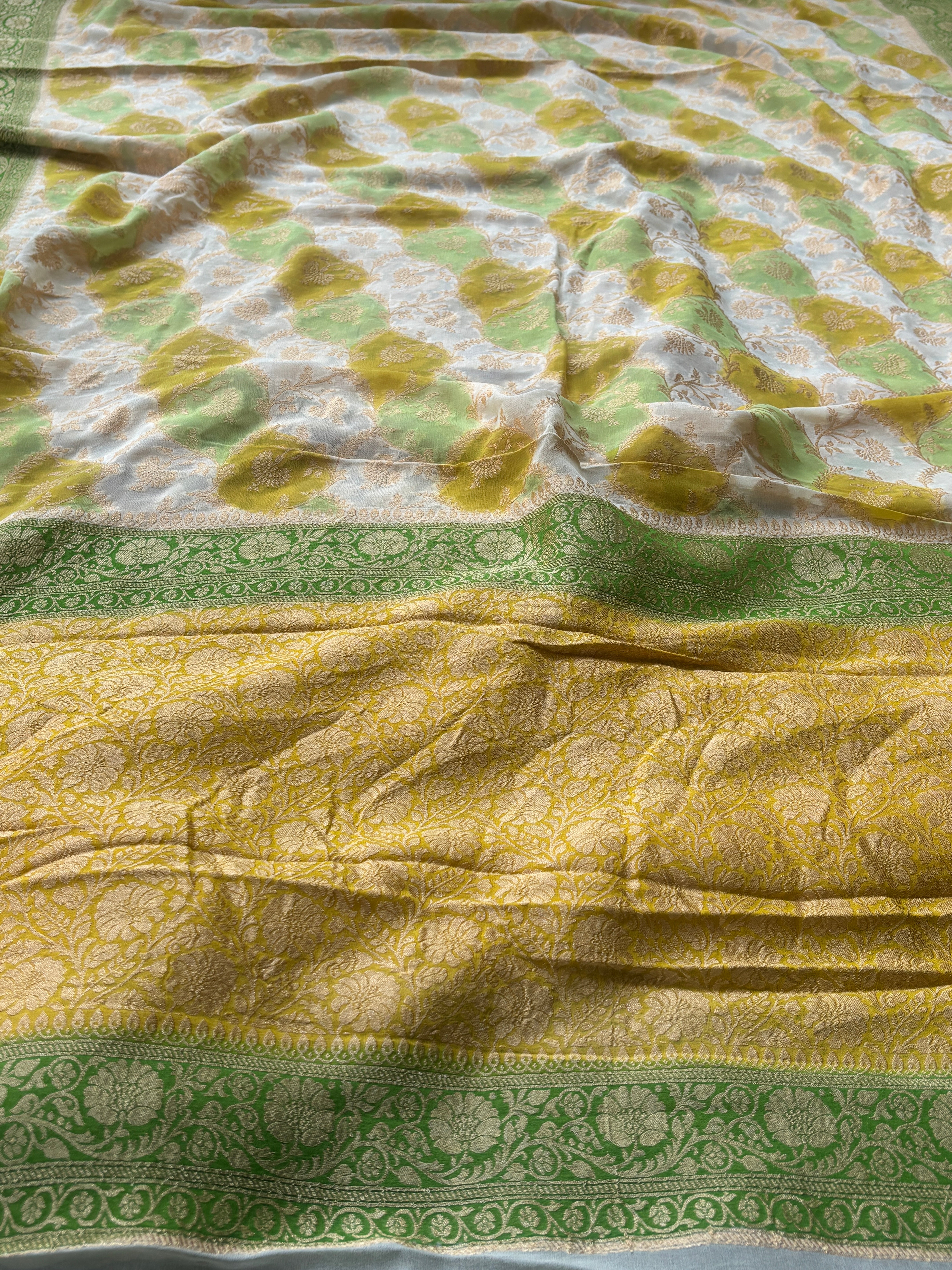 Close-up of intricate golden zari jaal weaving on pastel Khaddi Georgette Banarasi saree