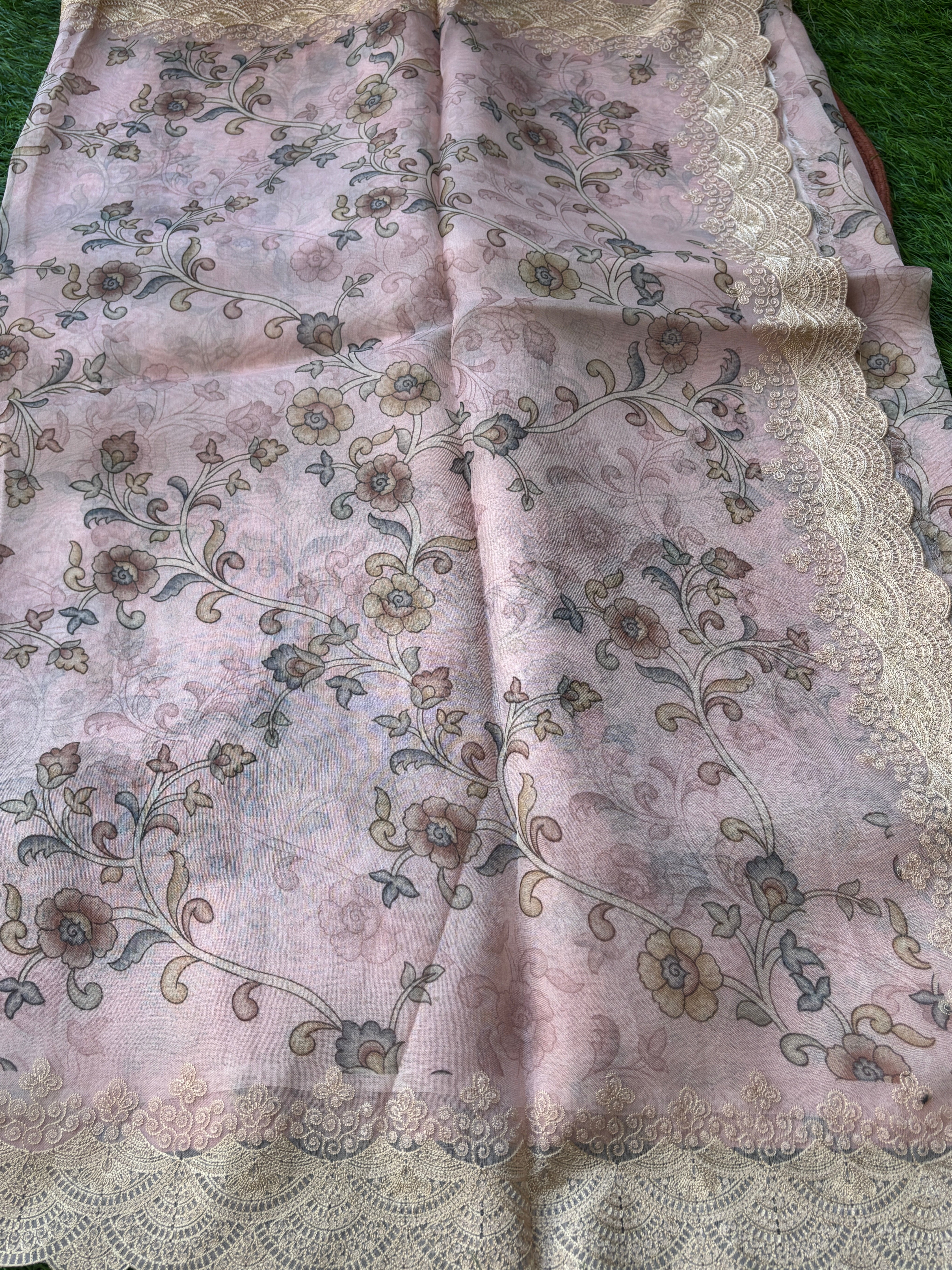 Intricate cutwork border of pastel pink organza saree with fine detailing and elegant craftsmanship