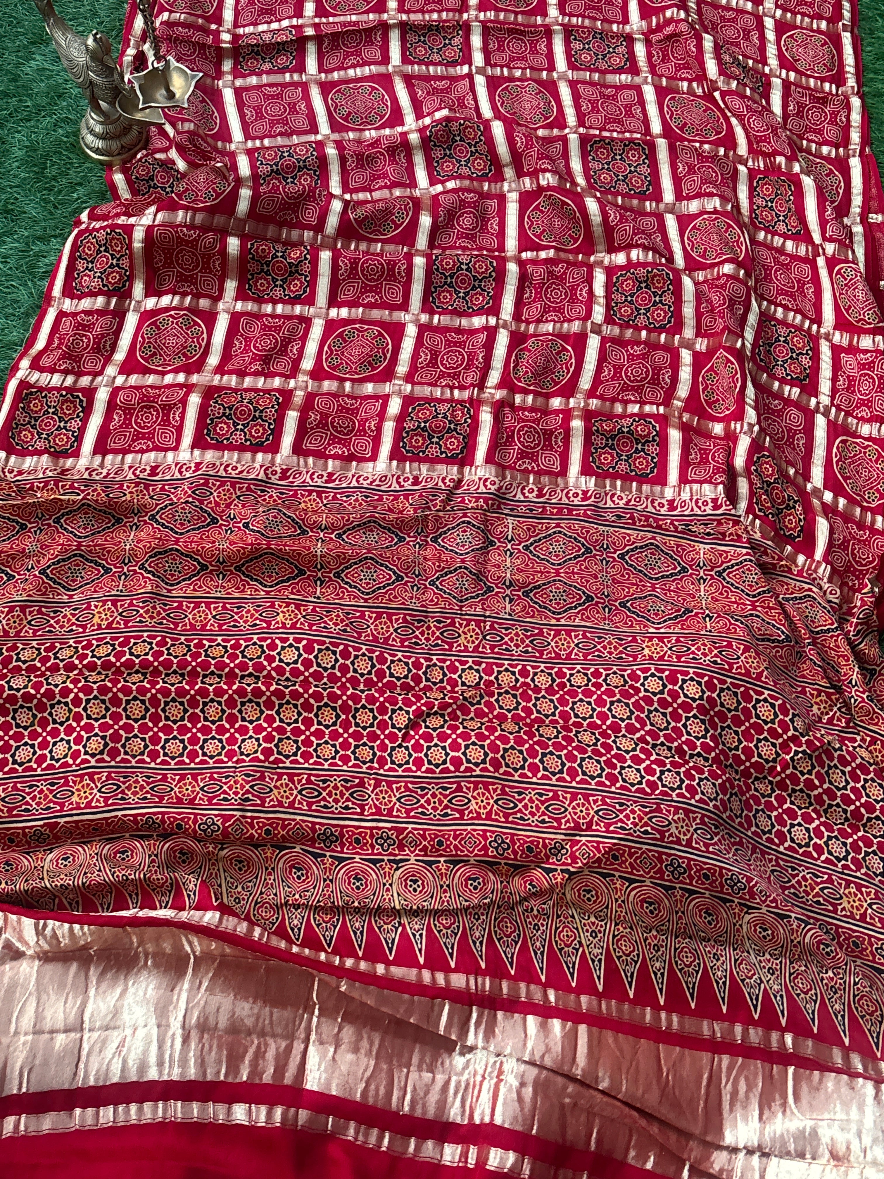 Rich red Gharchola saree pallu featuring intricate traditional Ajrakh pattern