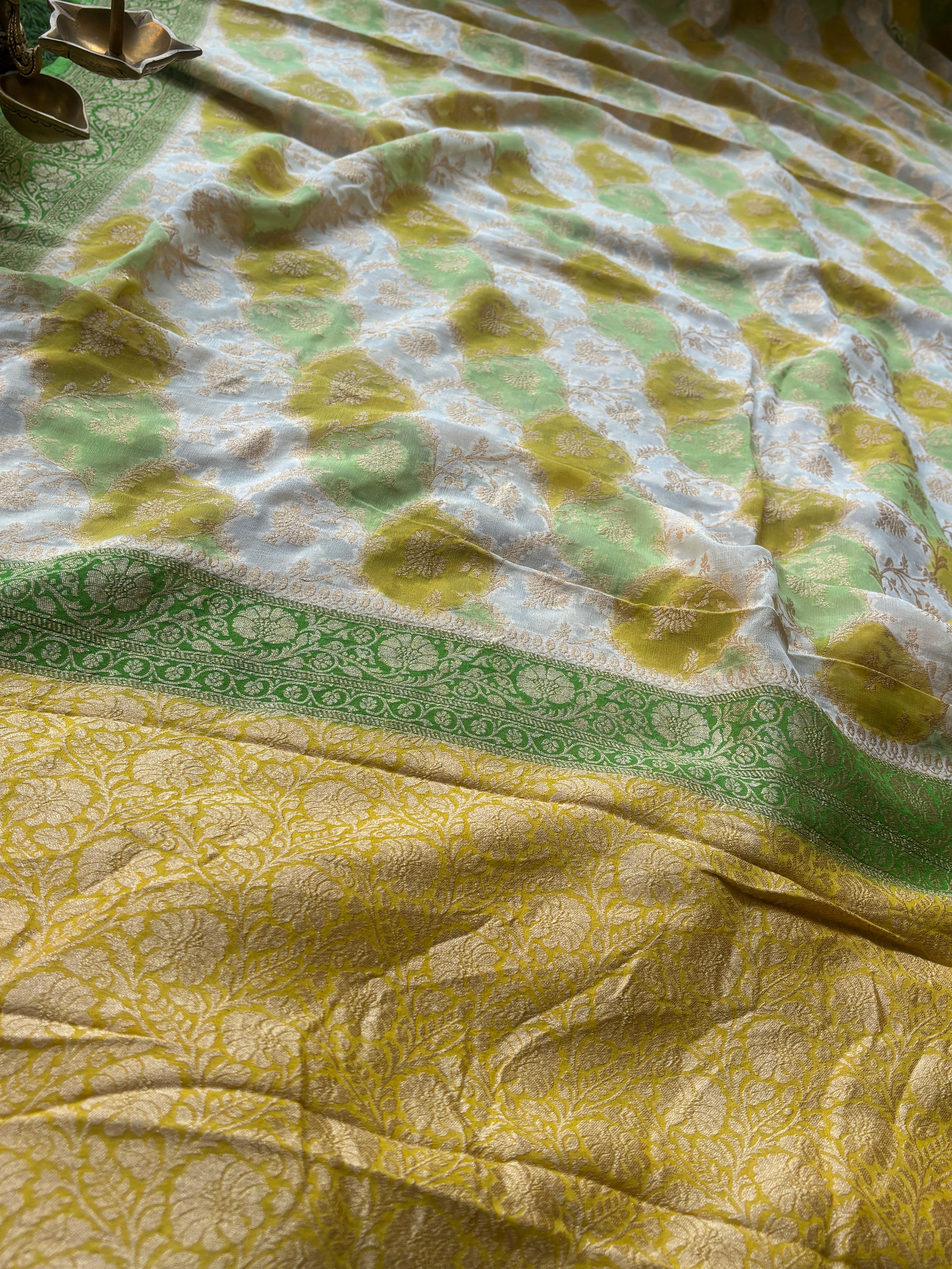 Close-up of intricate golden zari jaal weaving on pastel Khaddi Georgette Banarasi saree