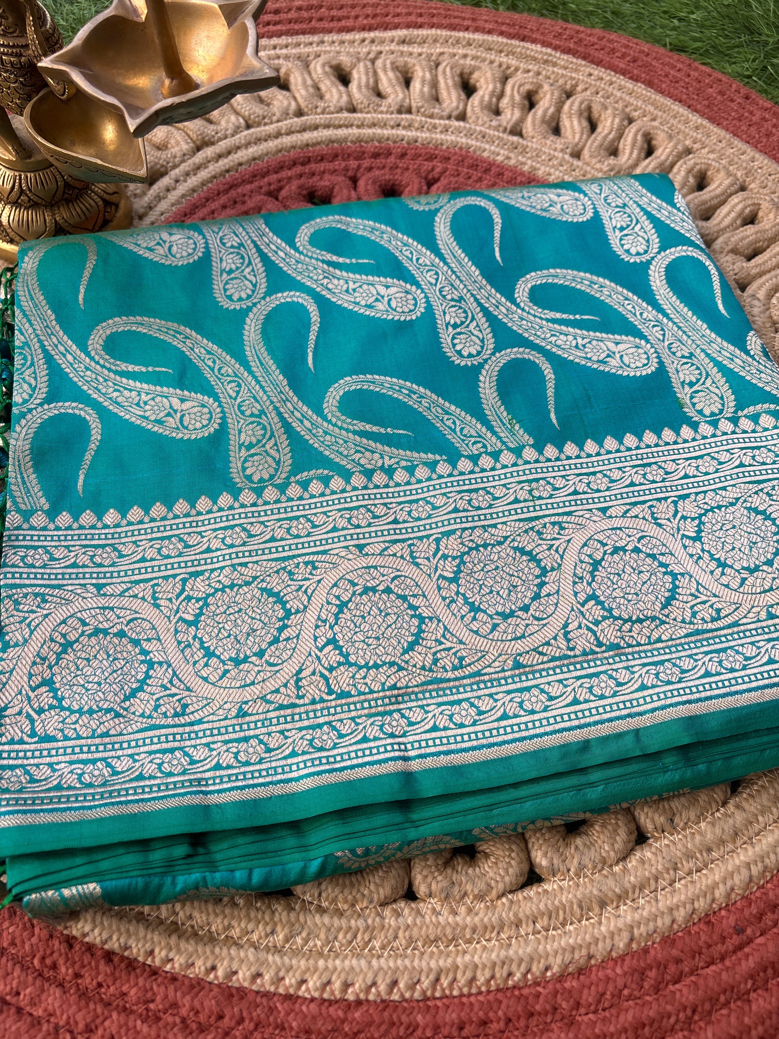 Sea green Katan silk Banarasi saree with allover mango motifs and silver zari broad border, traditional festive party wear with running blouse.