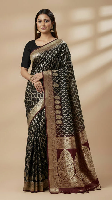 Woman wearing a black and gold saree with a red blouse on a beige background