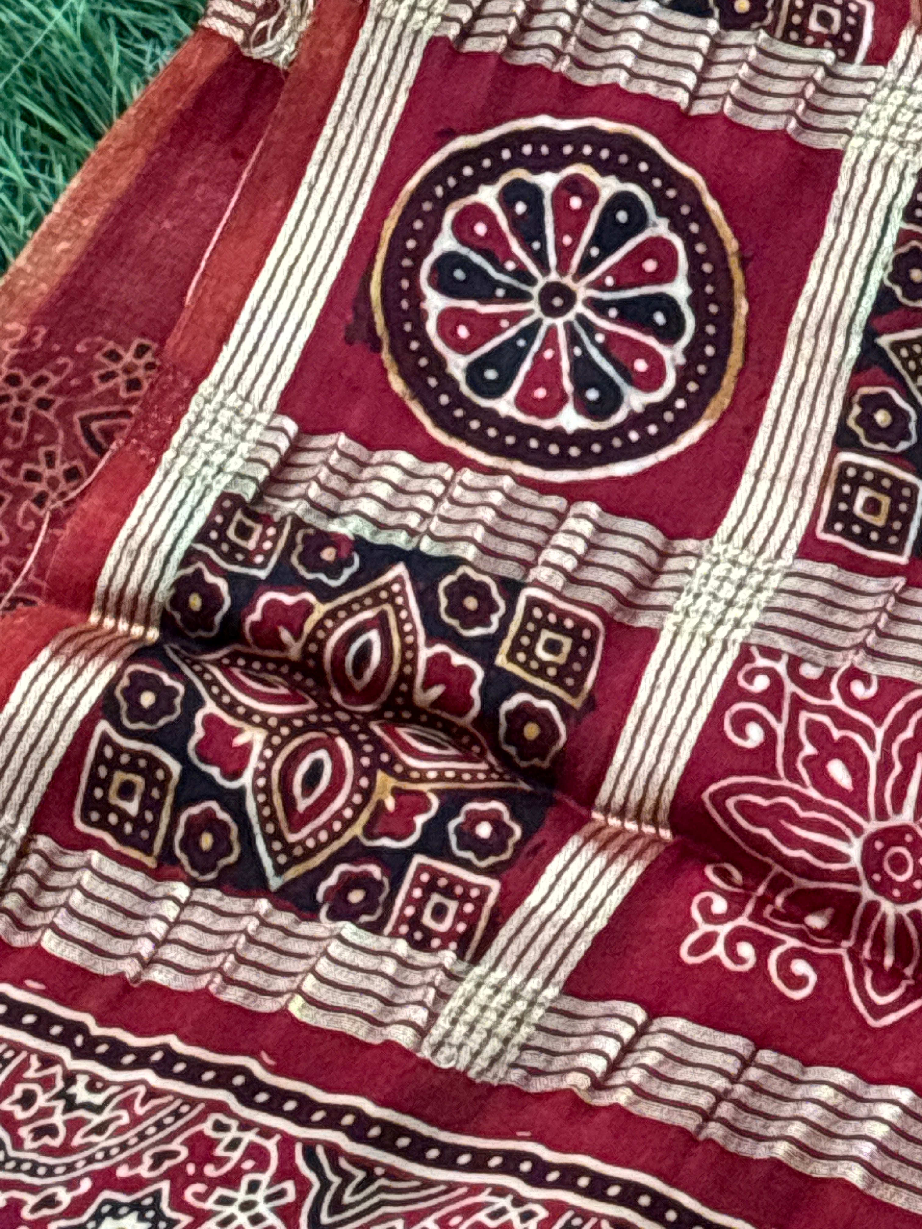 Close-up of golden gharchola checks on red modal silk fabric