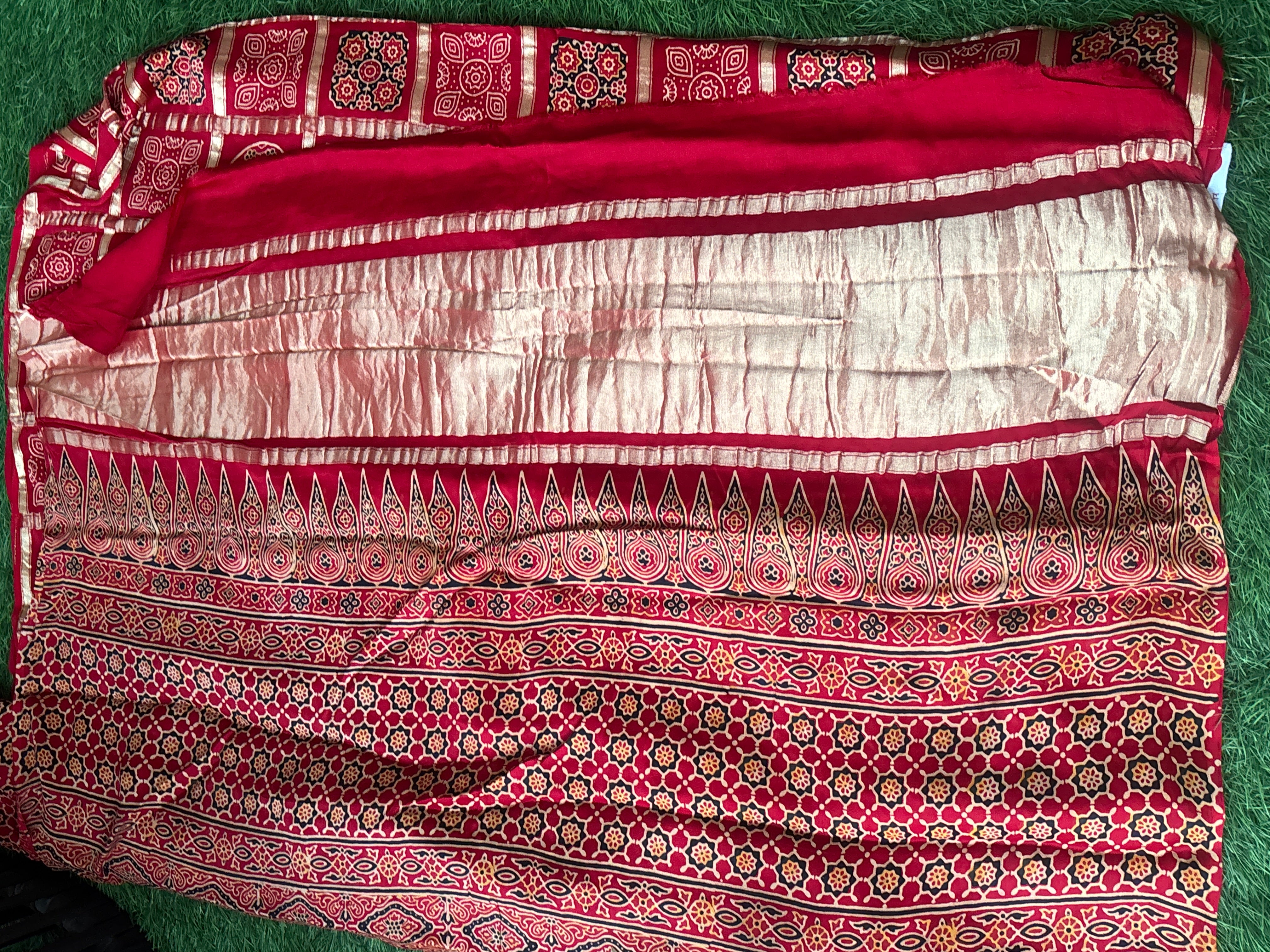 Rich red Gharchola saree pallu featuring intricate traditional Ajrakh pattern